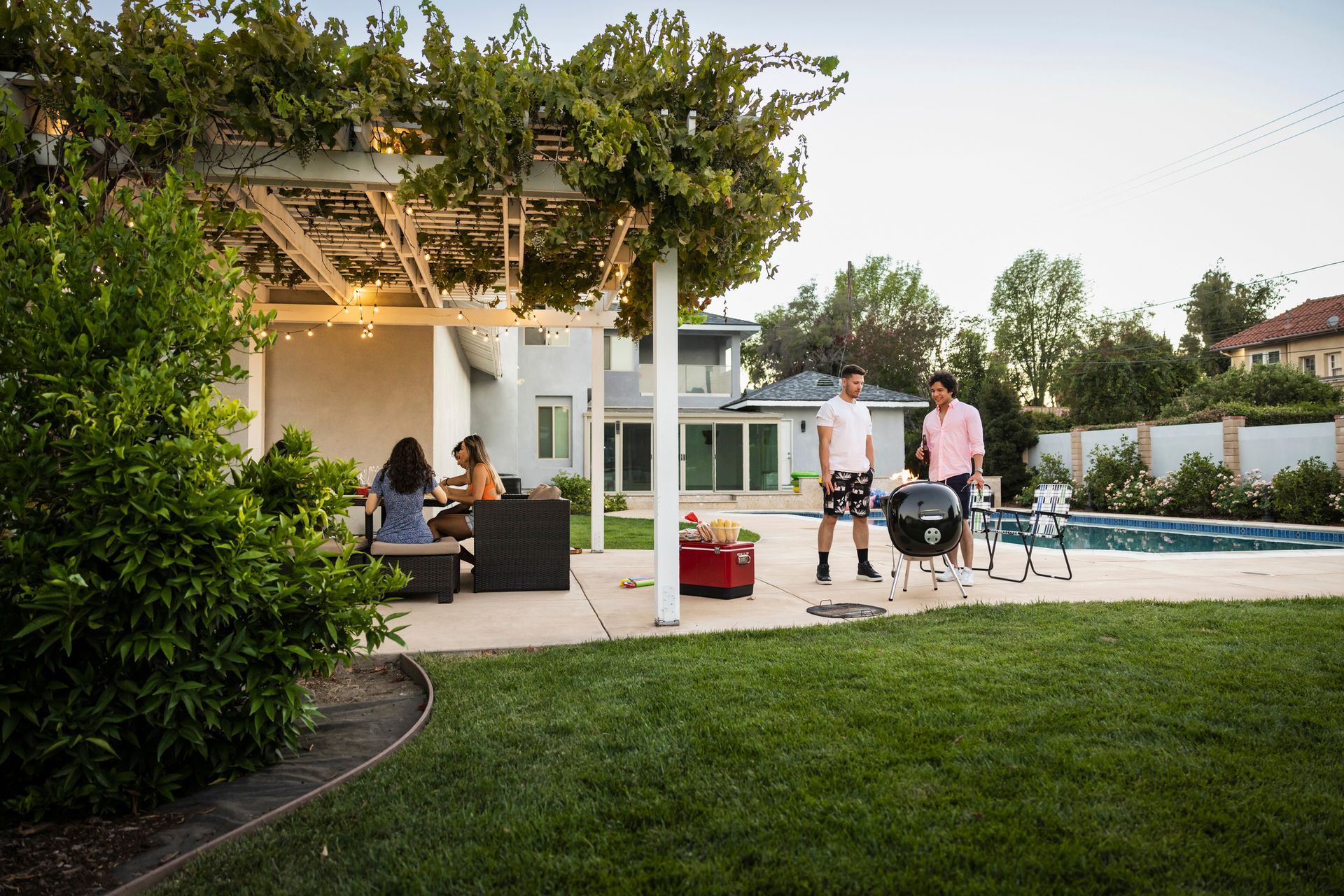 A wooden pier with support beams sits over muddy ground near water. A wheelbarrow and ladder are underneath.