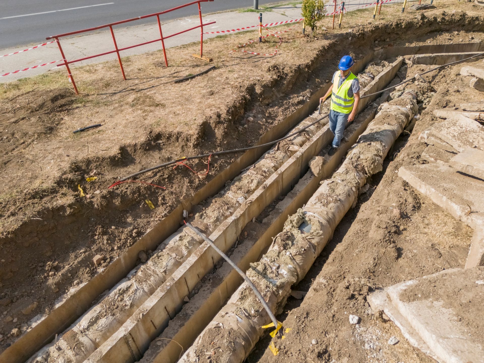 Man in protective suit working under a house with dirt and debris.