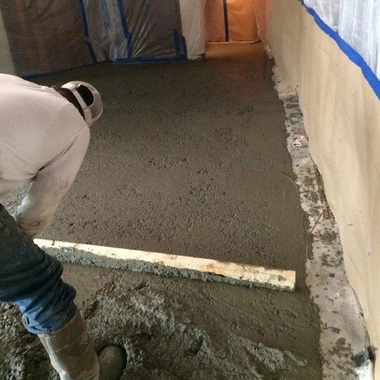 A foundation repair expert leveling a damaged concrete slab.