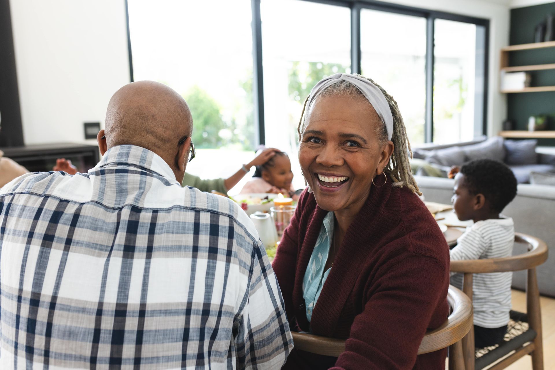 An elderly woman is sitting at a table with her family.