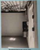 A monochrome room with equipment, electrical wiring, and a sealed label at the bottom.