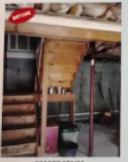 Basement stairs with wooden treads and support beams. Red support pole, items on a shelf.
