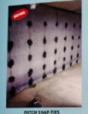 Concrete wall with evenly spaced black snap-ties.