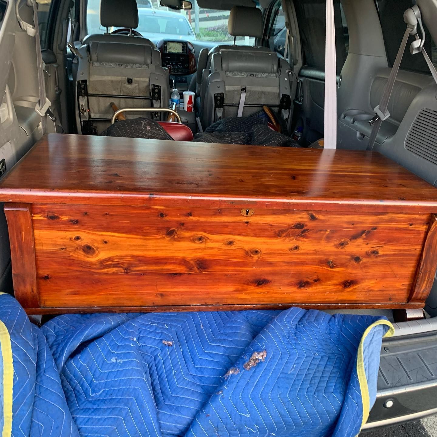 A wooden chest is sitting in the back of a car.