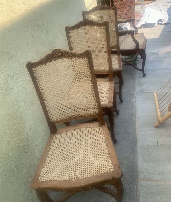 A row of wooden chairs with wicker seats