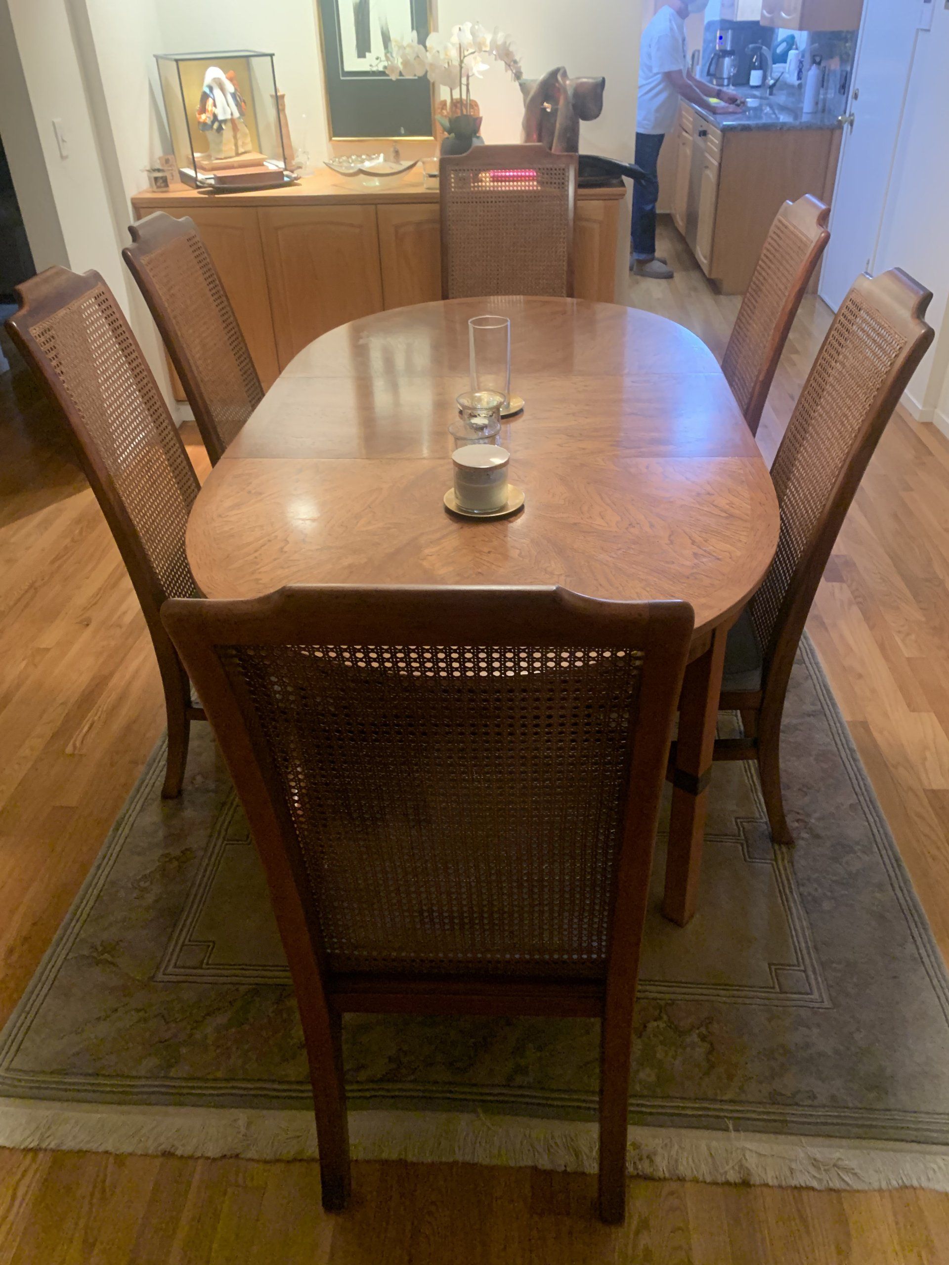 A wooden dining table with wicker chairs in a kitchen.