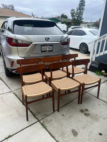 A group of chairs are sitting in front of a silver car.