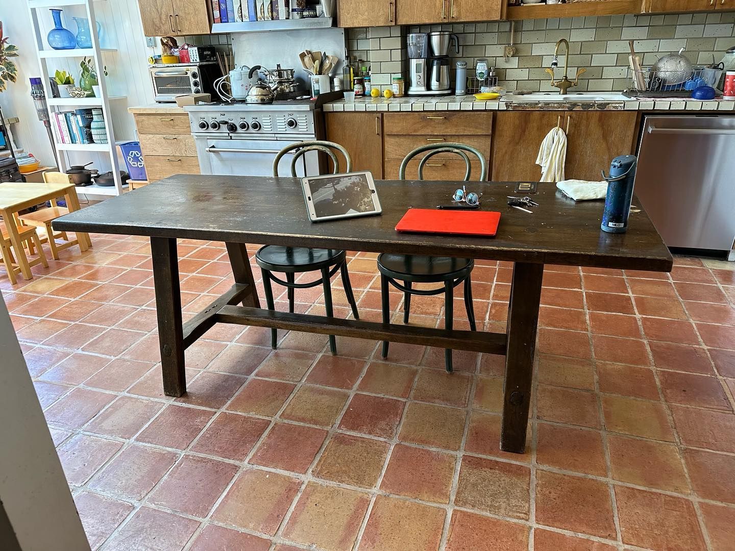 A kitchen with a wooden table and chairs and a tablet on it.