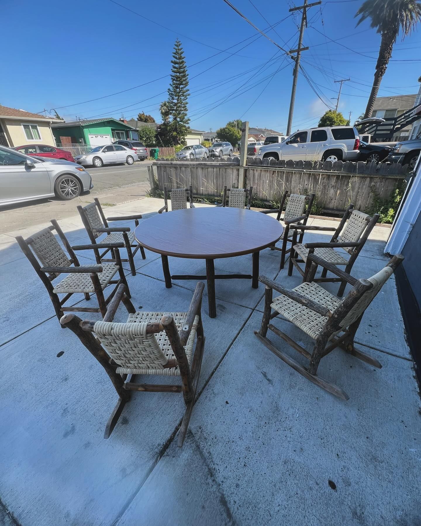 A group of rocking chairs are sitting around a table on a patio.