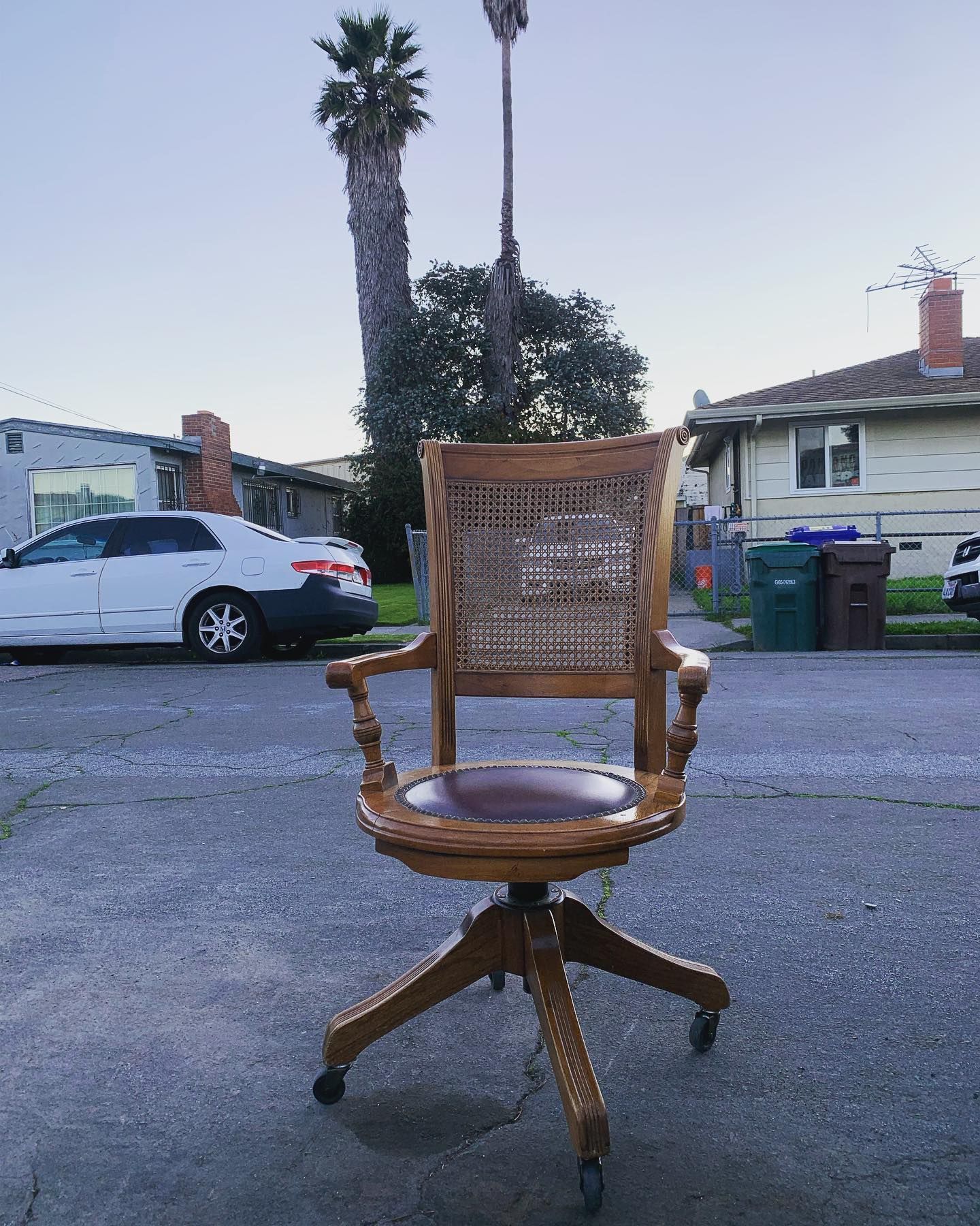 A wooden chair is parked on the side of the road