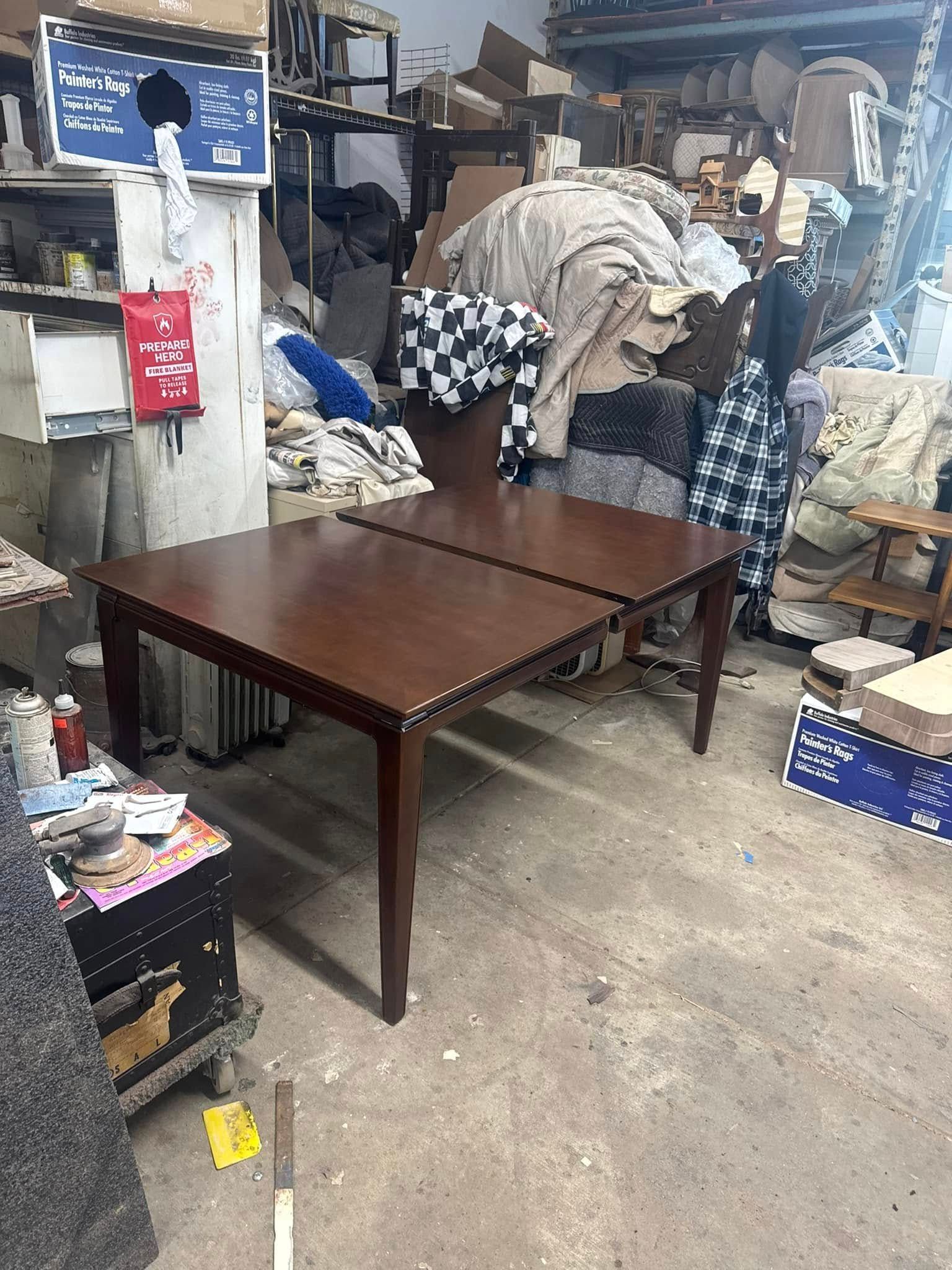 Two wooden tables are sitting in a messy room.
