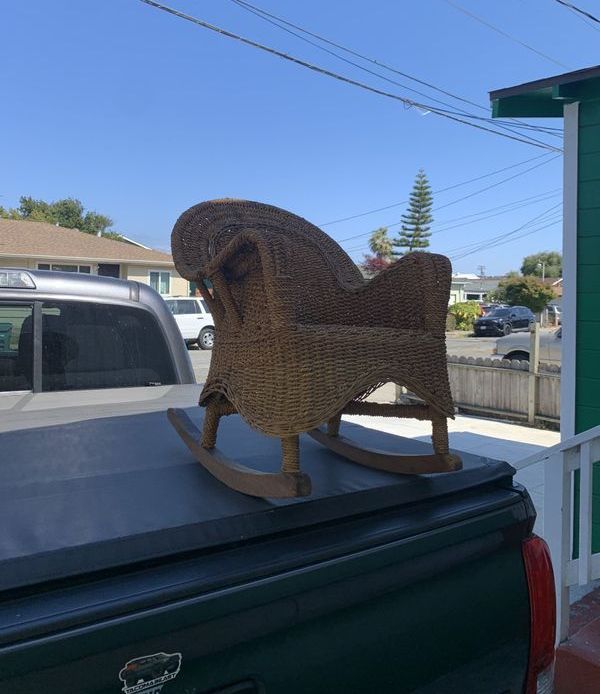 A rocking chair is sitting on the back of a truck