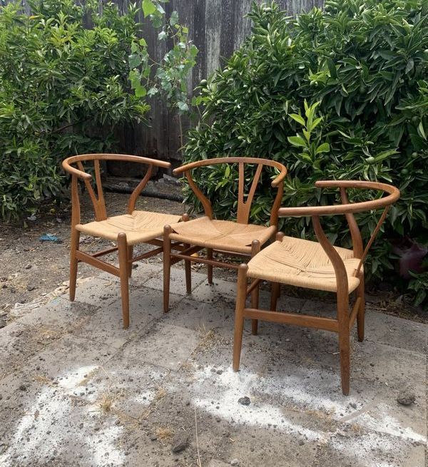 Two wooden chairs are sitting next to each other in a garden.
