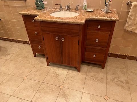A bathroom with a wooden vanity and a sink.