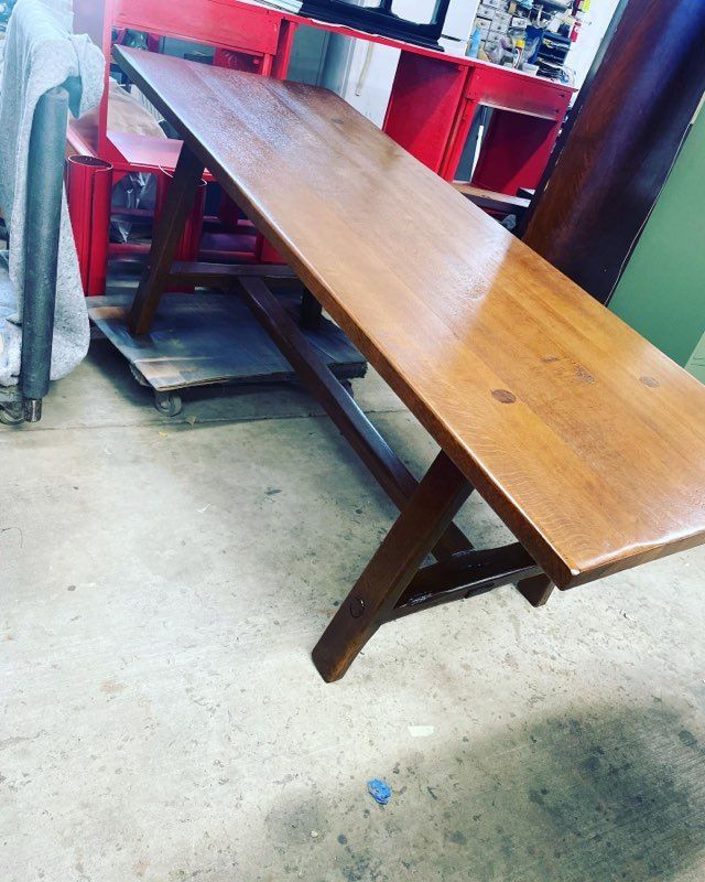 A wooden table is sitting on a concrete floor in a room.