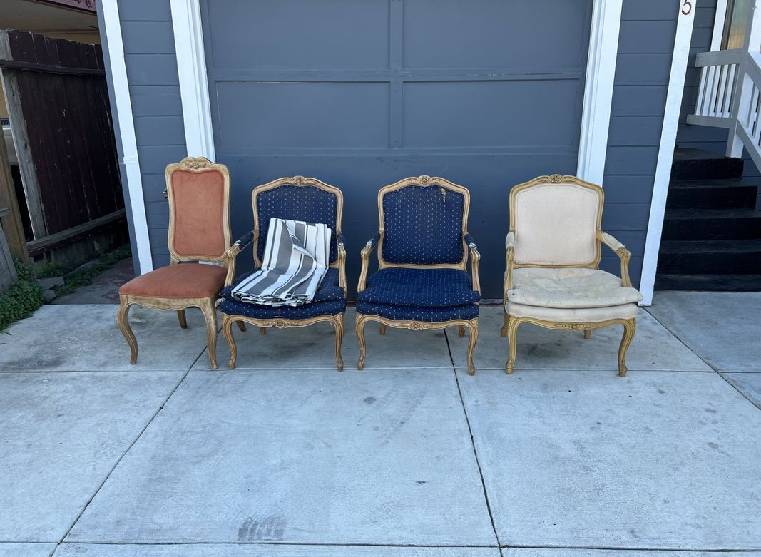 Four chairs are lined up in front of a garage door.