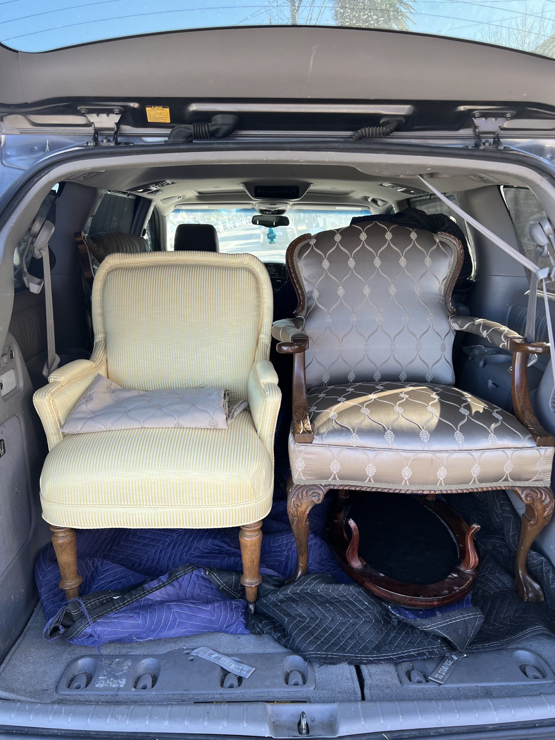 Two chairs are sitting in the back of a car.