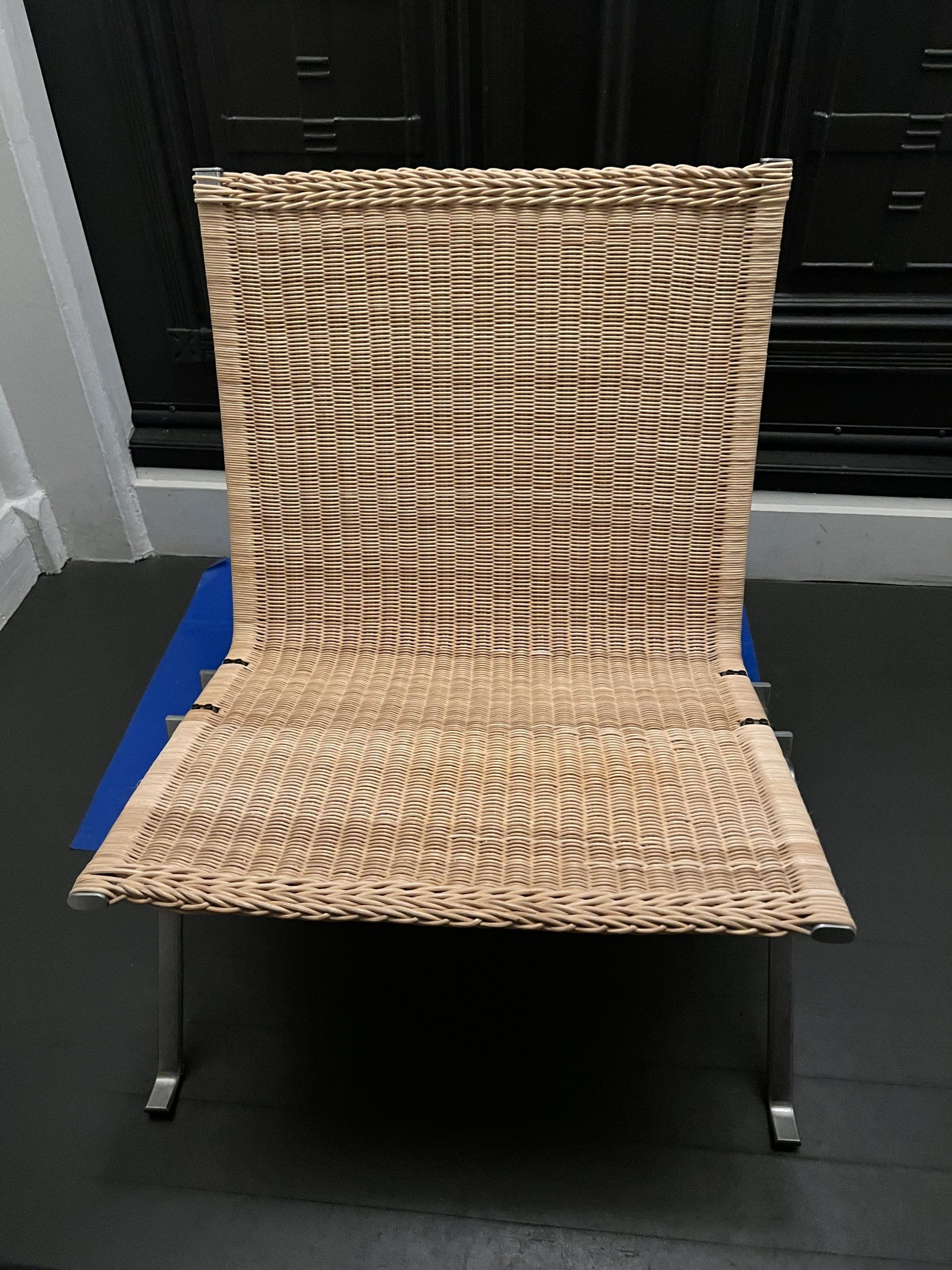 A wicker chair is sitting on a black floor