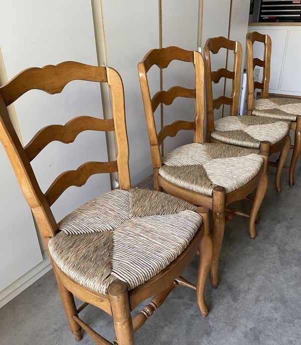 A row of wooden chairs with woven seats