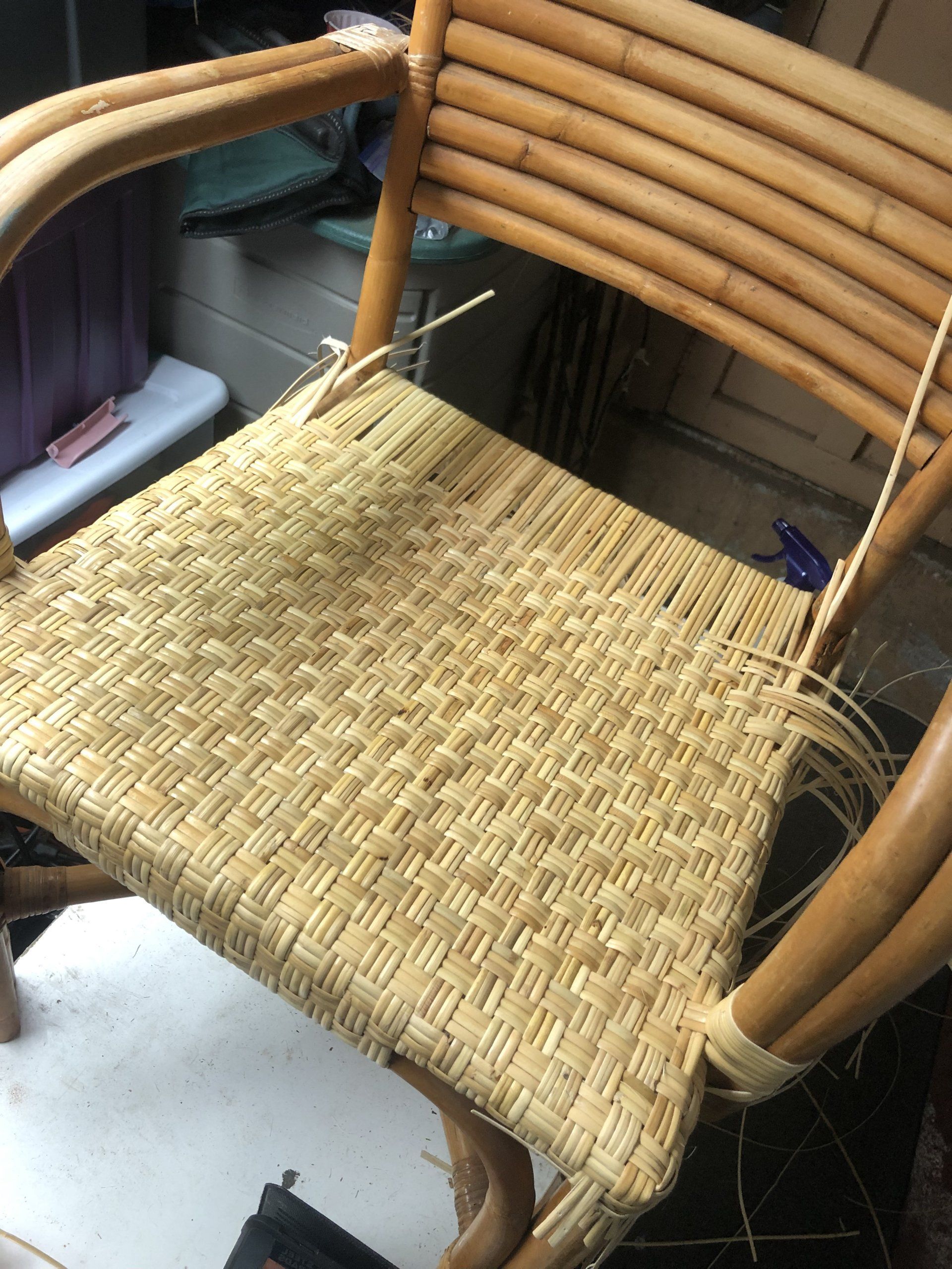 A wicker chair is being repaired in a room