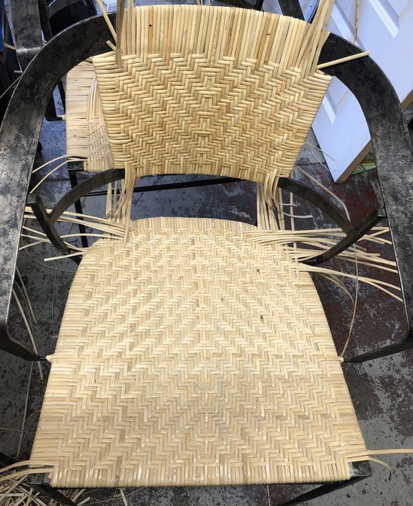A wicker chair is being made in a workshop.