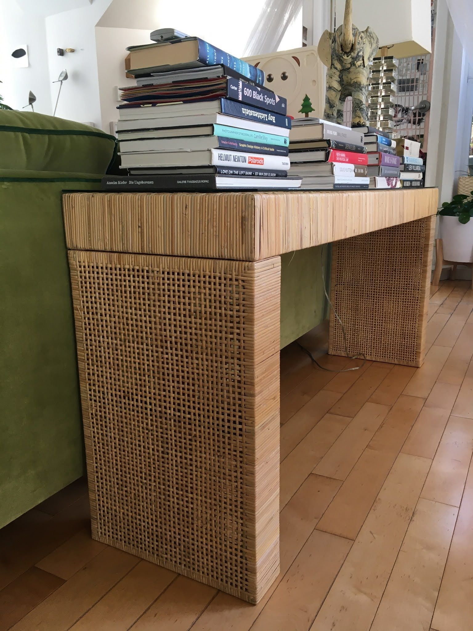 A wooden table with a stack of books on top of it in a living room.