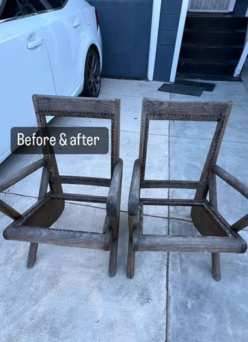 Two wooden chairs are sitting on a sidewalk in front of a white car.