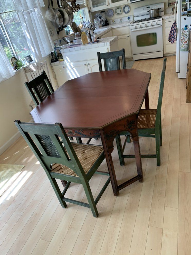 A kitchen with a table and chairs in it.