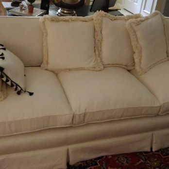 A white couch with a lot of pillows on it