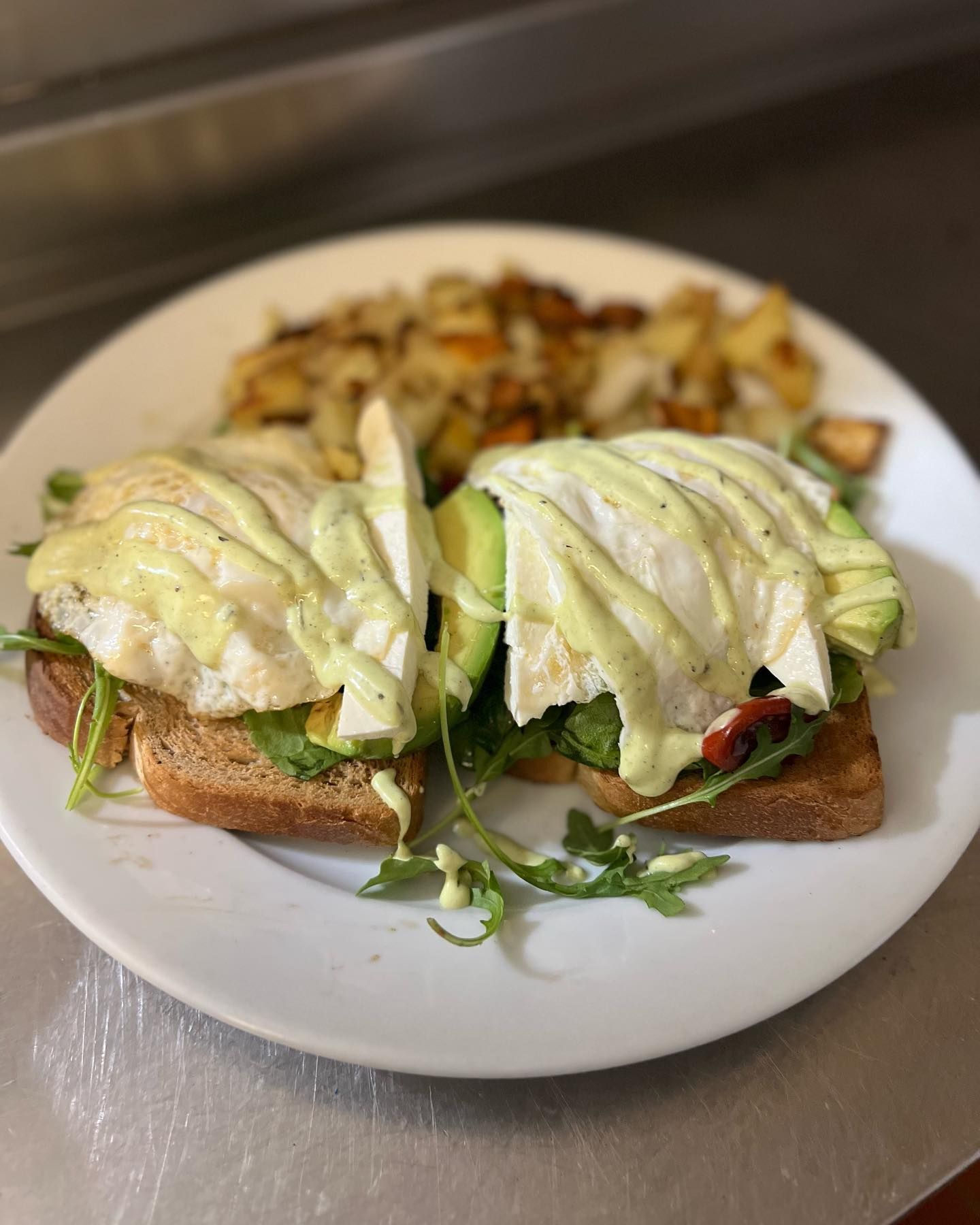 A white plate topped with a sandwich and eggs on toast.