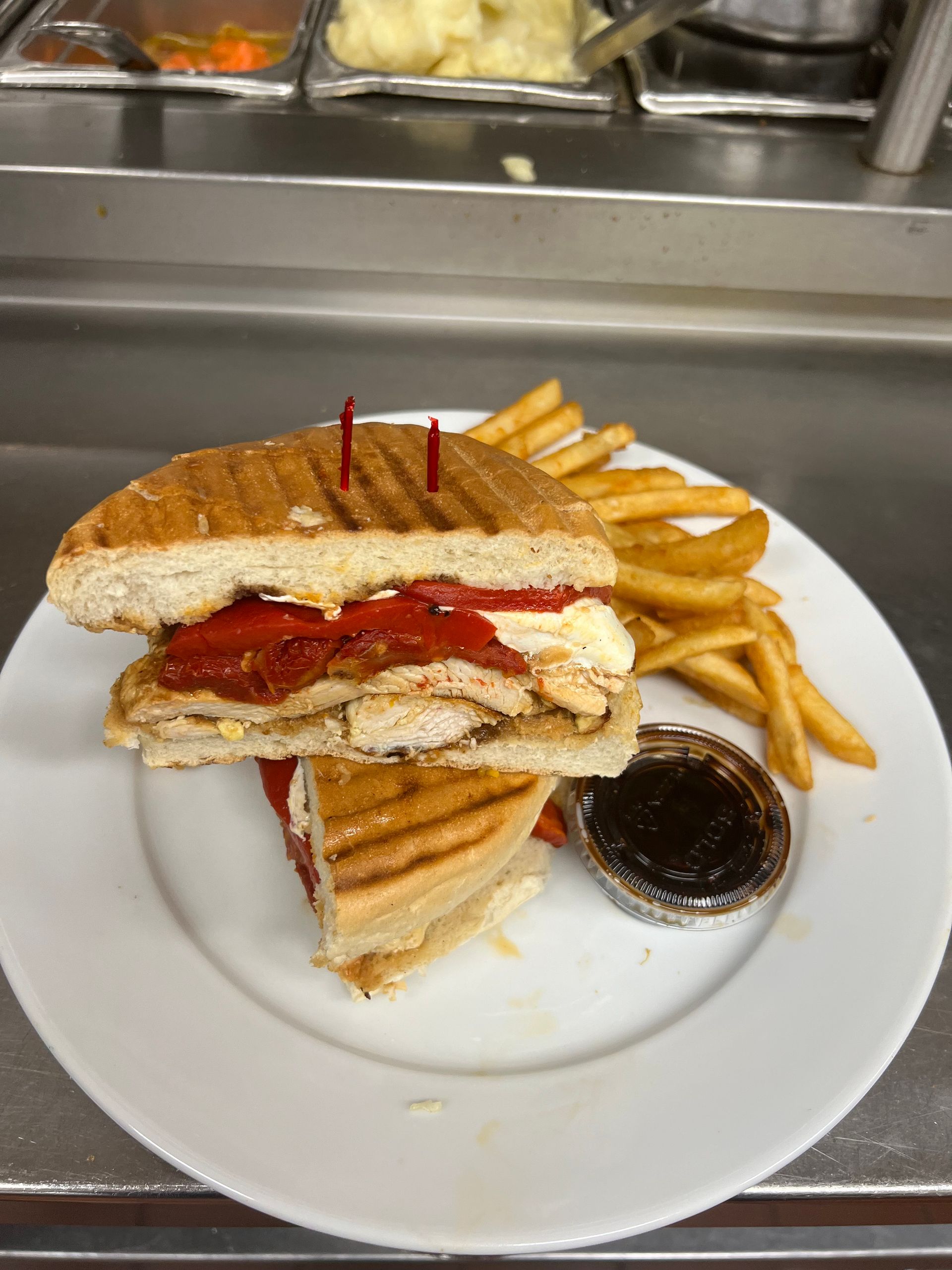 A white plate topped with a sandwich and french fries.