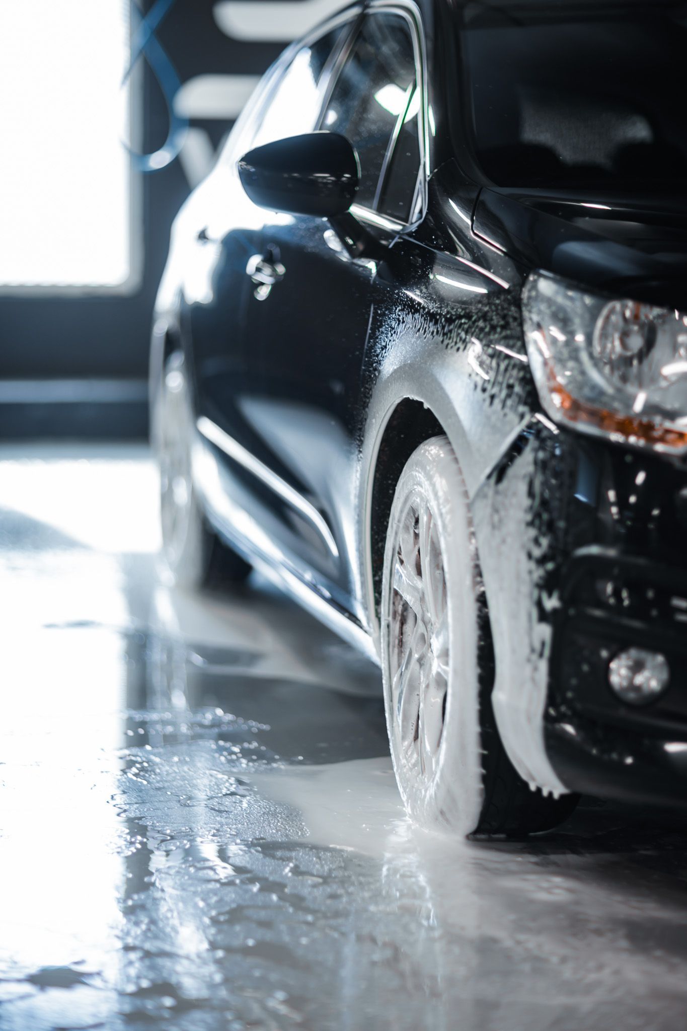 En mann iført en svart skjorte med teksten «din bilplejeservice» på den