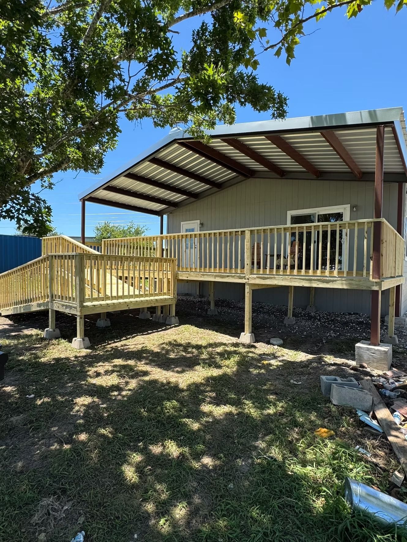 Person using a drill to secure wooden framing on a construction site.