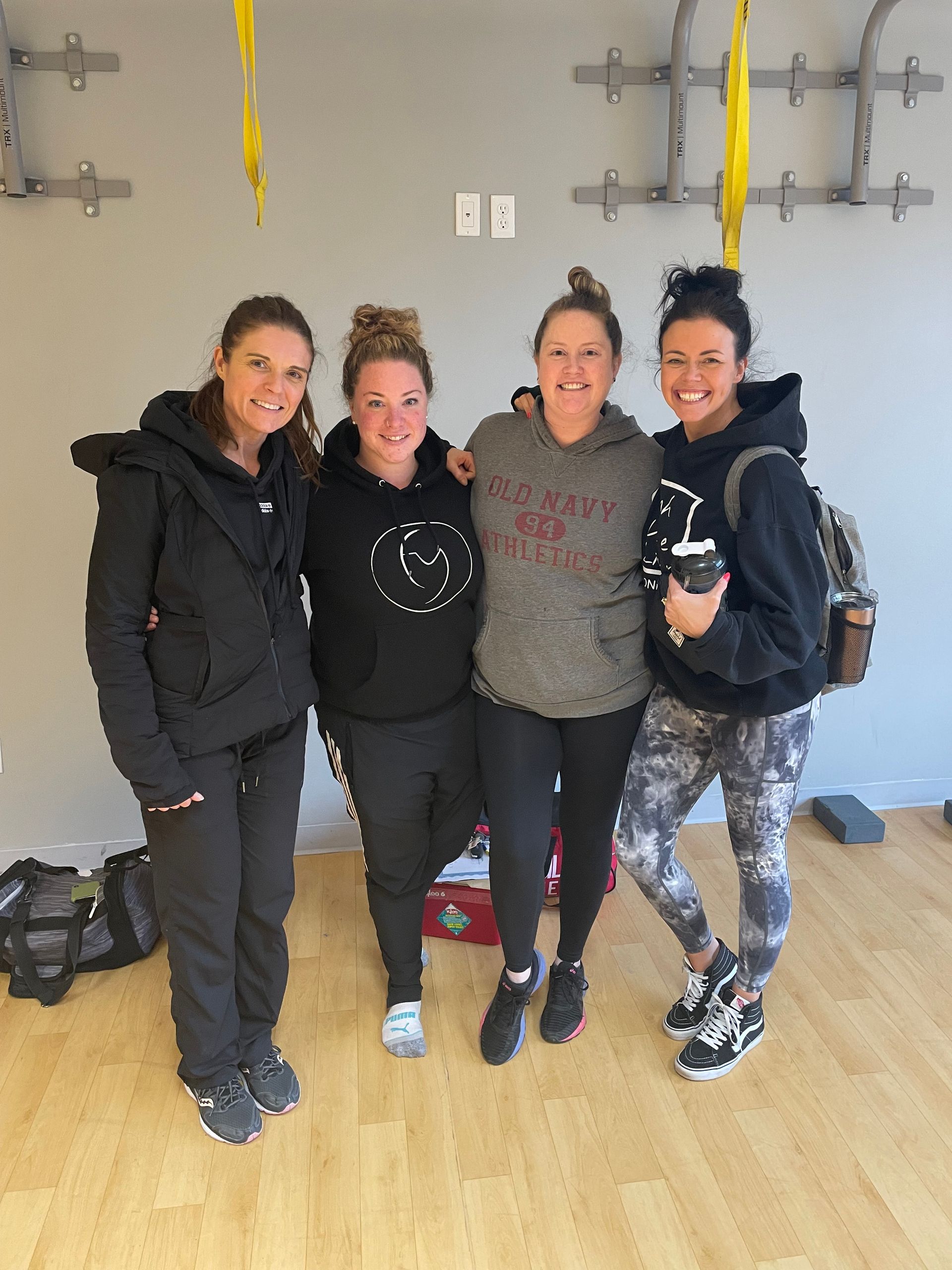 Four women are posing for a picture in a gym