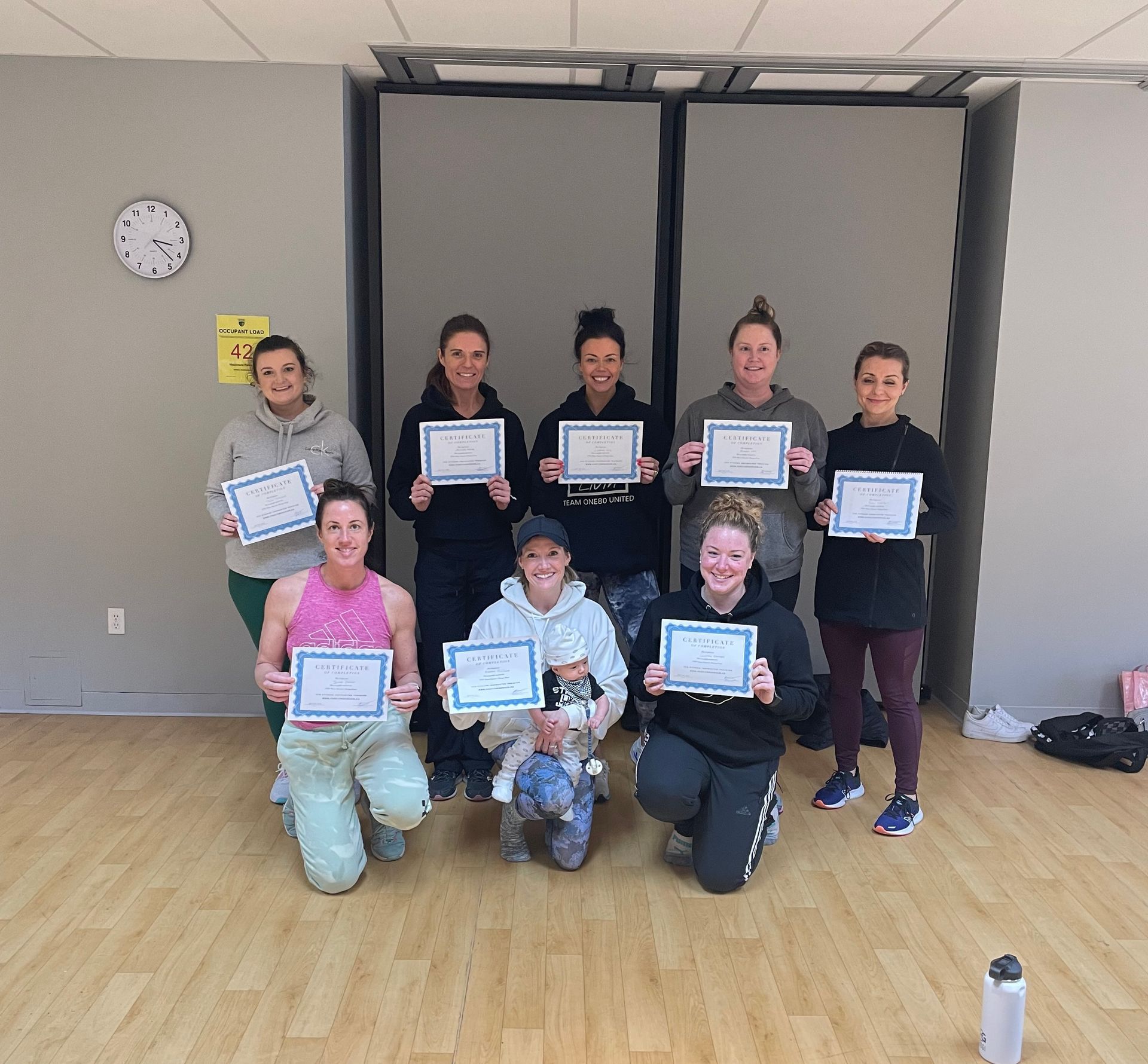 A group of women are posing for a picture while holding certificates