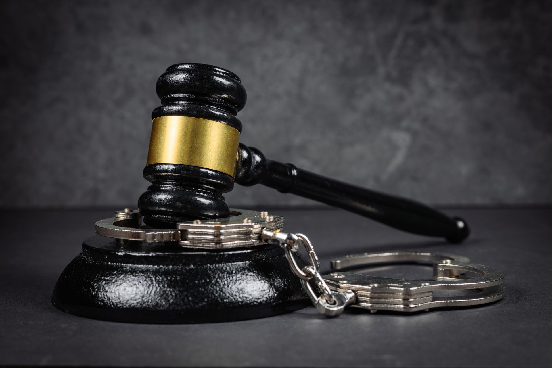 A judge 's gavel and handcuffs on a table.