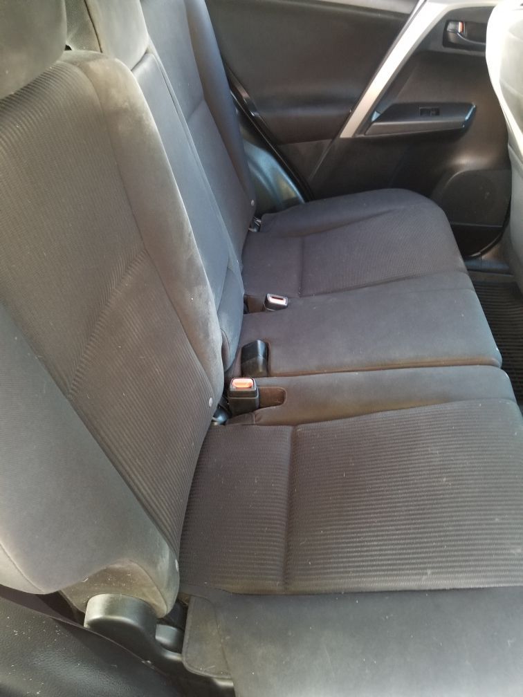 The back seat of a car with a seat belt on it.
