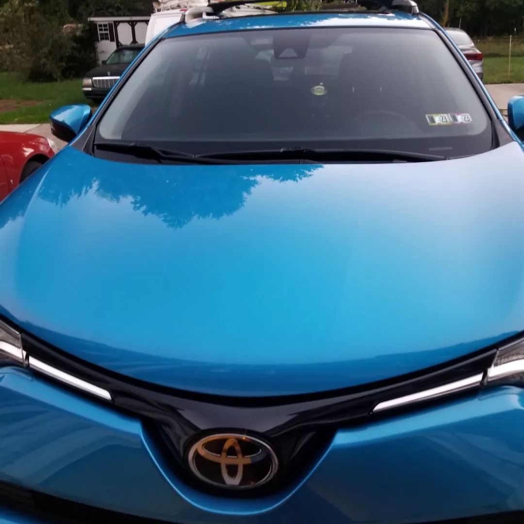 A blue toyota car is parked in a driveway