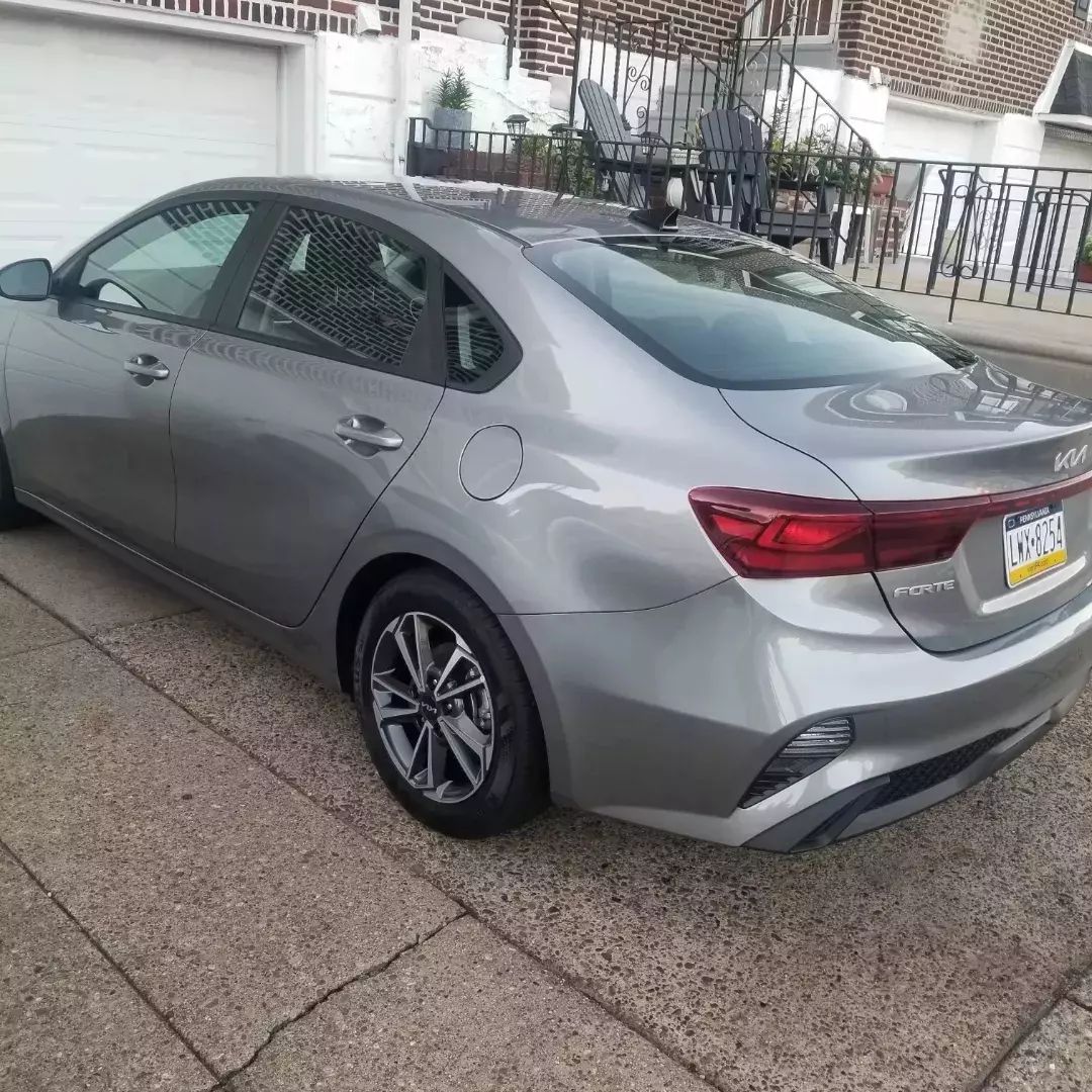 A silver car is parked in front of a garage.