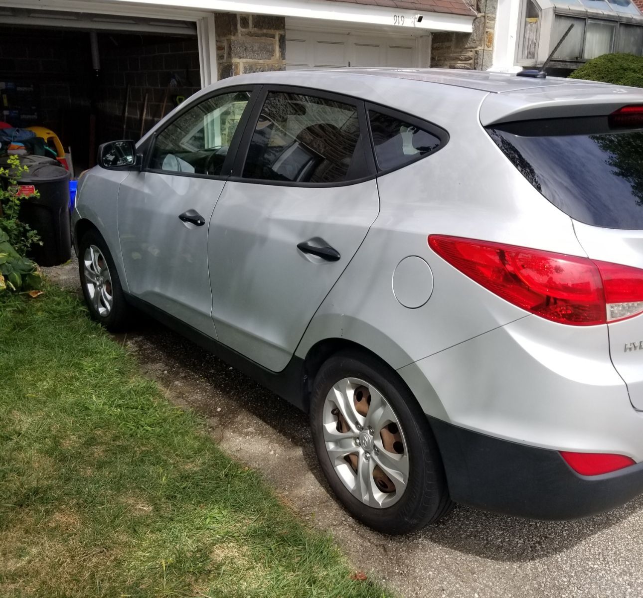 A silver car is parked in front of a garage