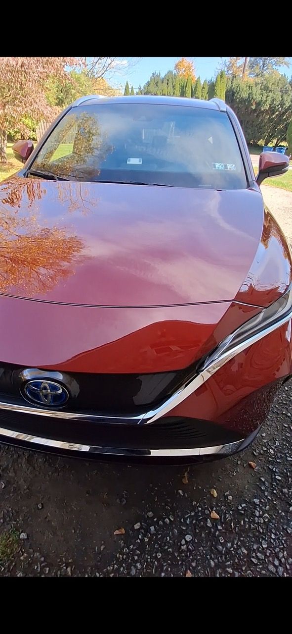 A red car is parked on the side of the road.