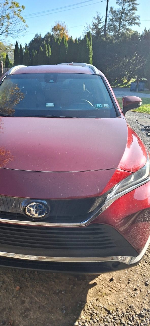 A red car is parked on the side of the road.
