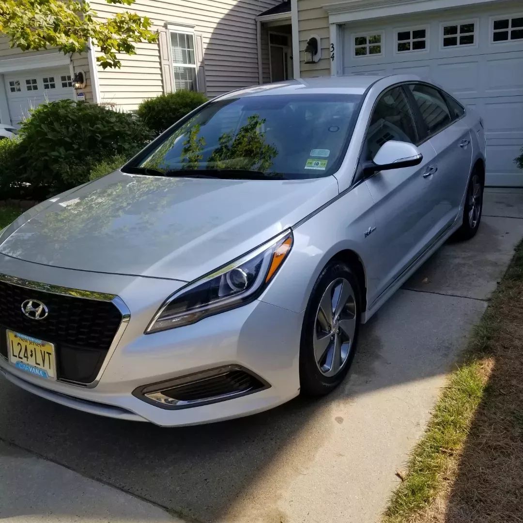 A silver car is parked in front of a garage door