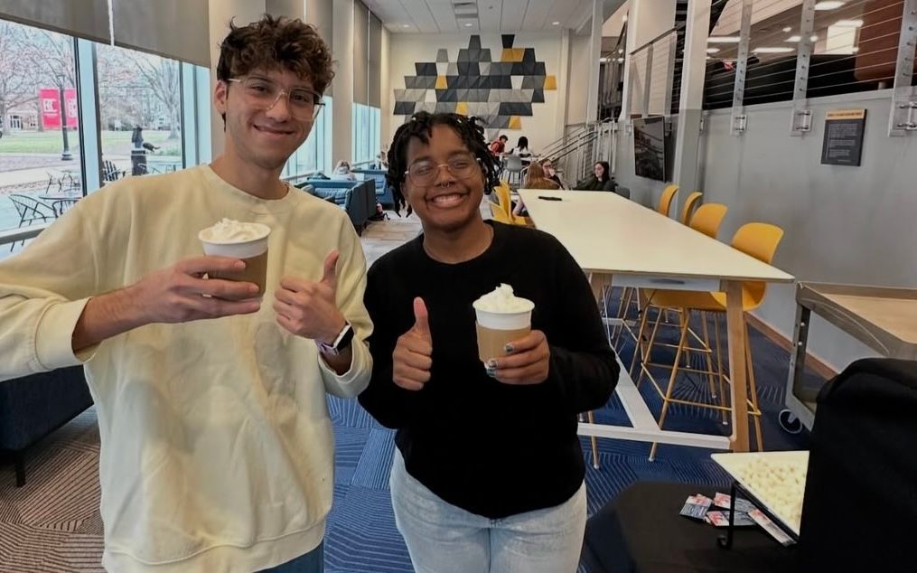 A large group of people are posing for a picture in a room.