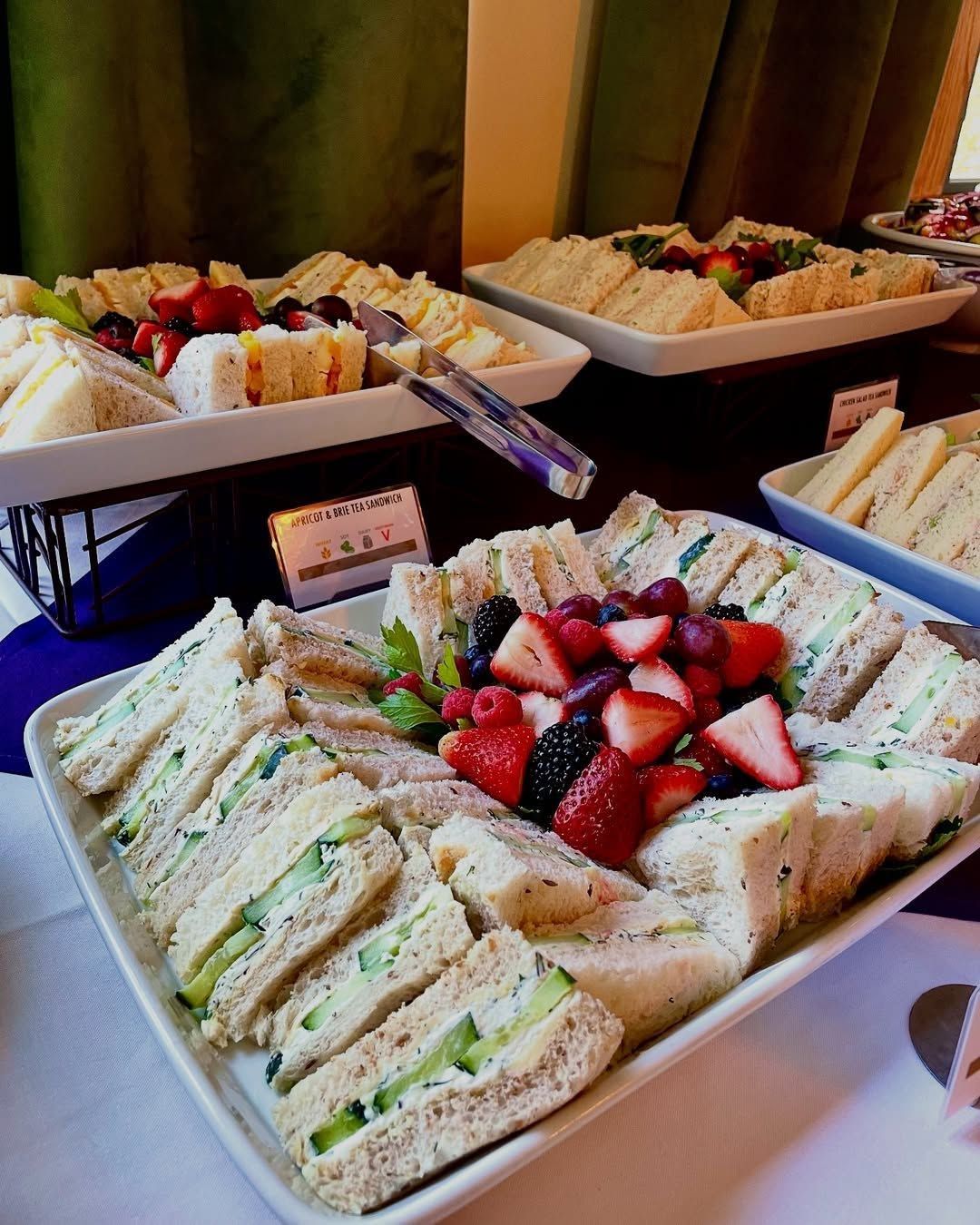 A buffet table with sandwiches and fruit on it.