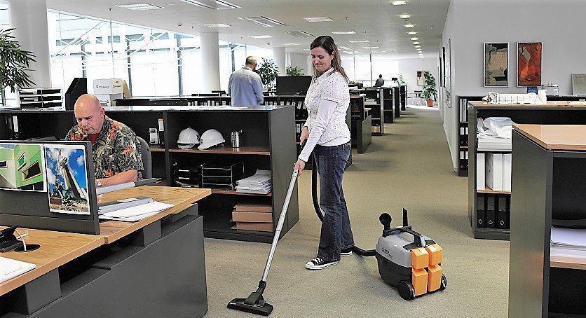 Woman vacuuming - cleaning office