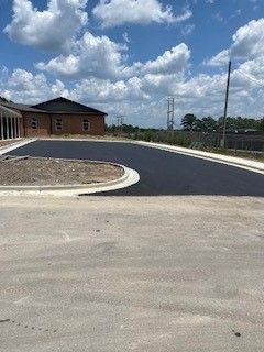 There is a building in the background and a lot of clouds in the sky.