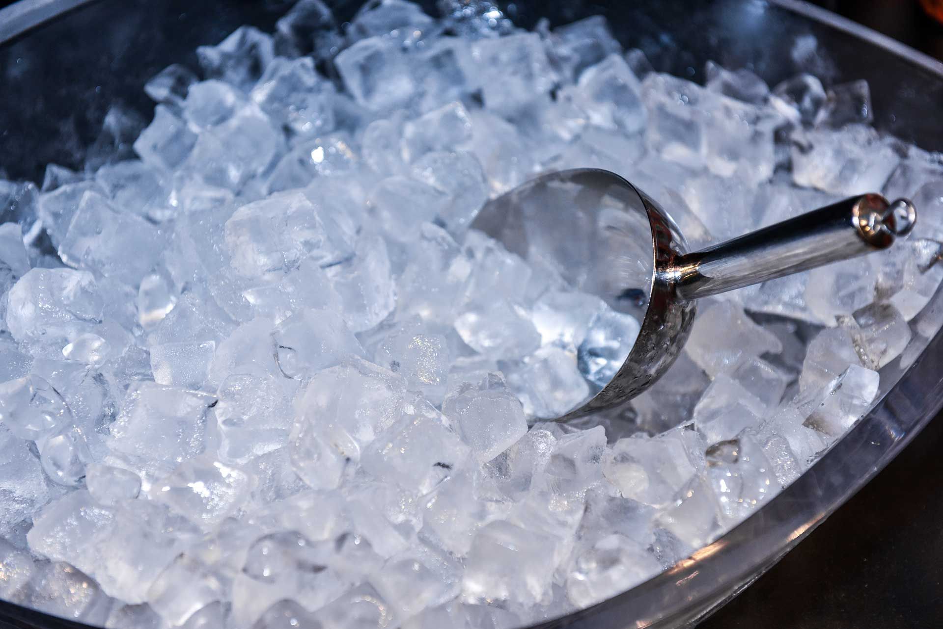 Iced scoop in bucket, highlighting fresh ice, provided by a reliable ice supplier for events.
