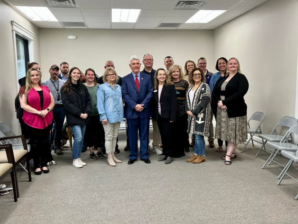 A group of people are posing for a picture in a room.