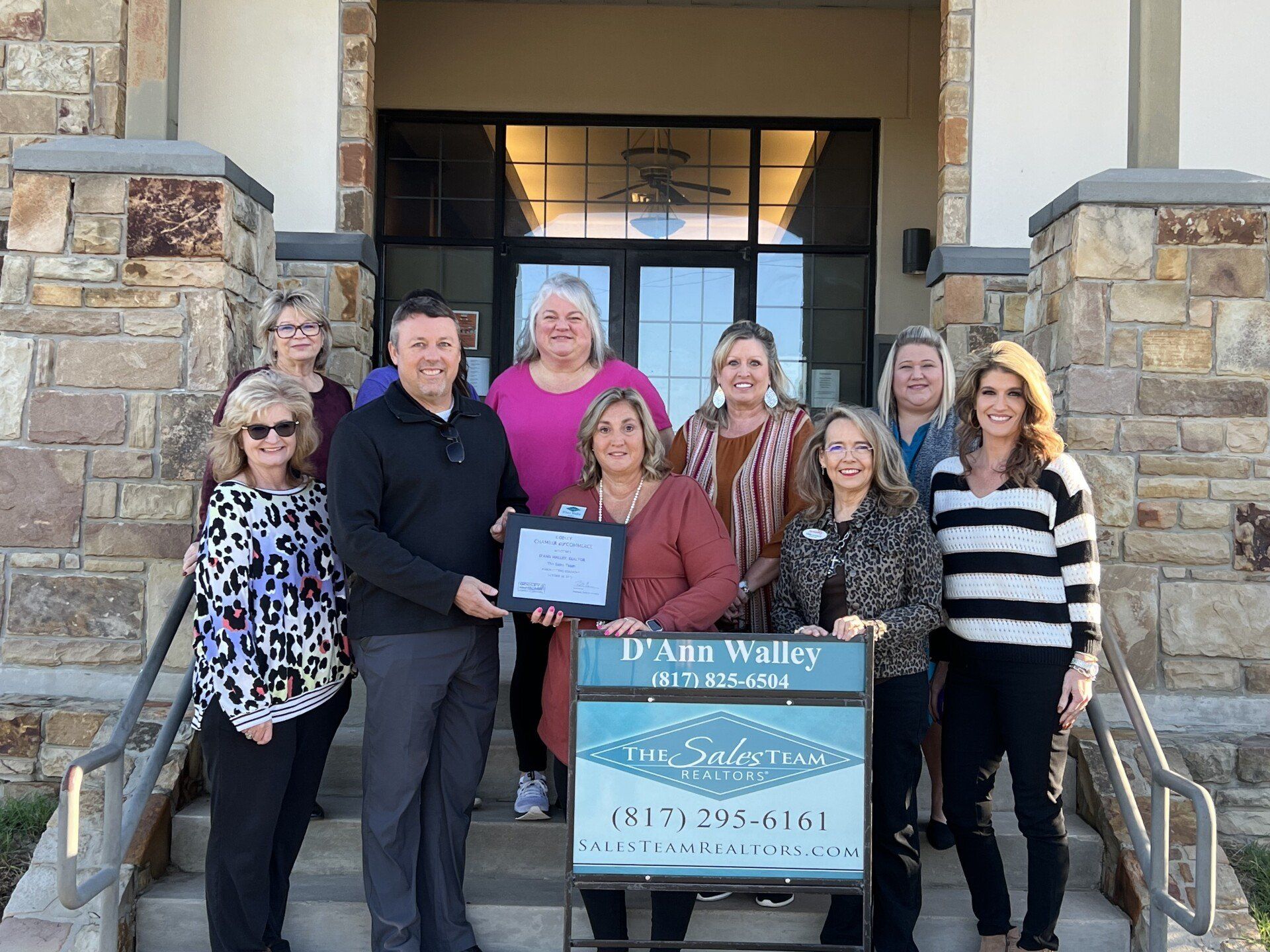 A group of people are posing for a picture in front of a building.